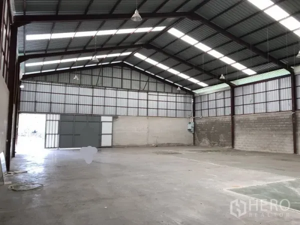 คลังสินค้า ให้เช่าในBueng Kum, Bangkok - มุมมองภายในโกดังแบบเคลียร์สแปน ประตูเข้าออกขนาดใหญ่ และตู้ยูทิลิตีบนผนัง.
