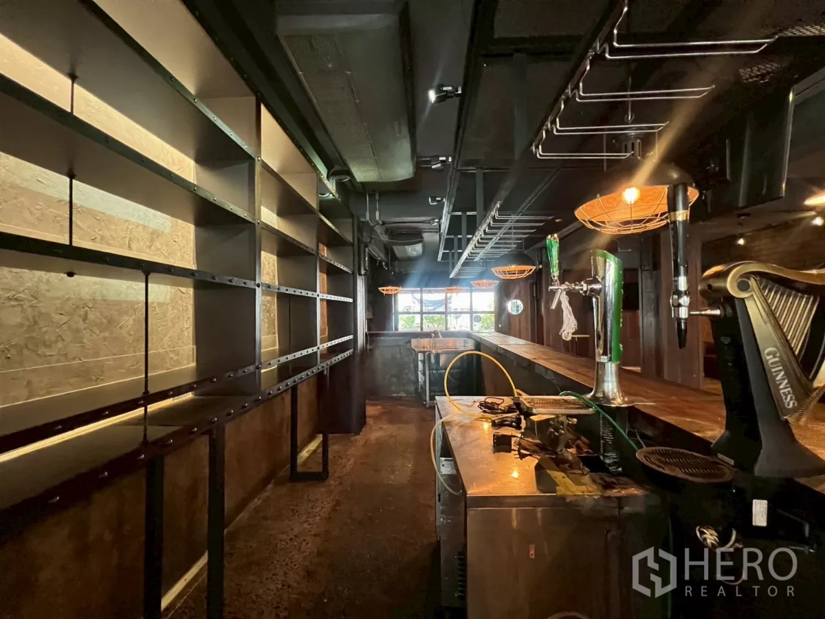 零售空间 出租 - 后吧区域，发光陈列架与啤酒龙头沿木吧台分布。