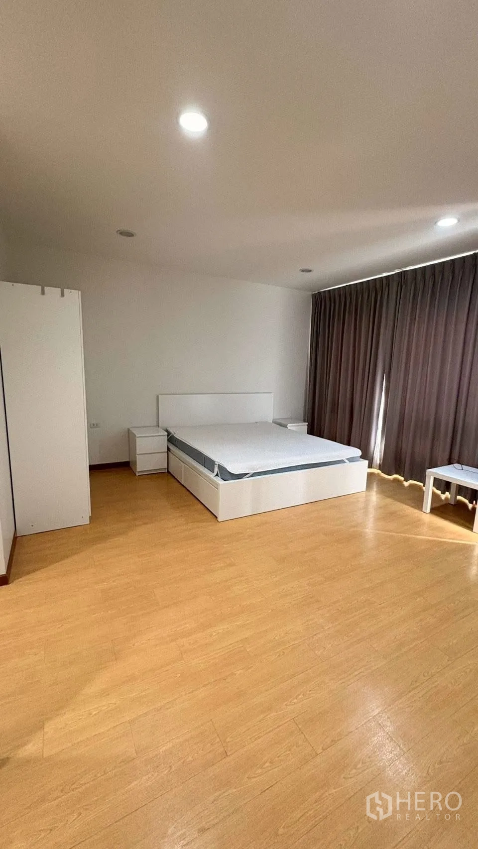 联排别墅 for rent in Phra Khanong, Bangkok - 卧室配窗帘、床与床头柜，筒灯照明。