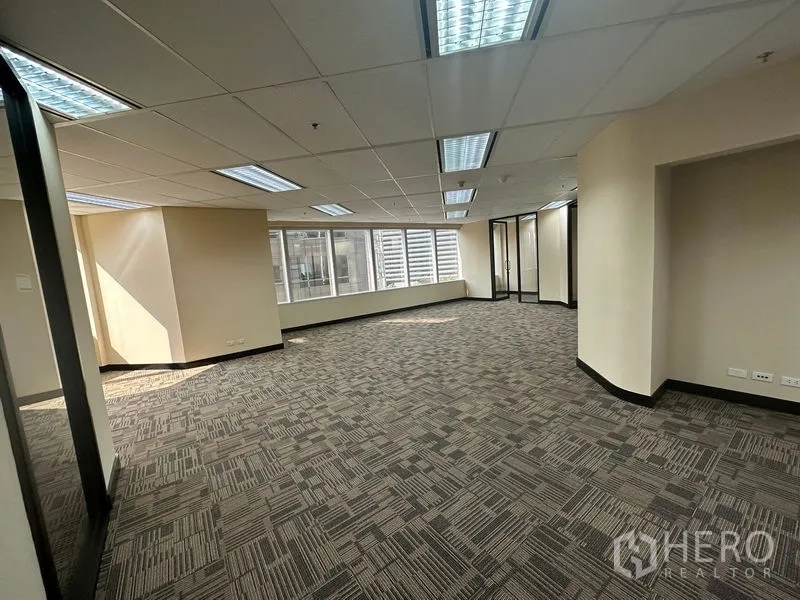 办公空间 出租 - 明亮的开放式办公区，大窗户、顶灯和纹理地毯砖。