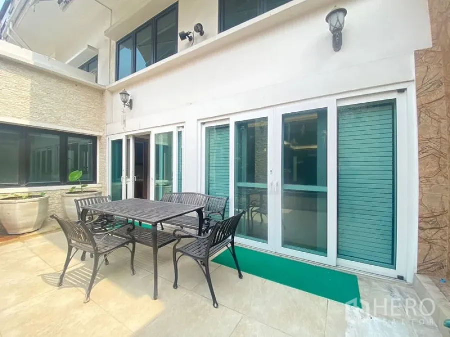 Detached House for sale in Khlong Toei, Bangkok - Private patio with outdoor dining set beside white-framed sliding glass doors.