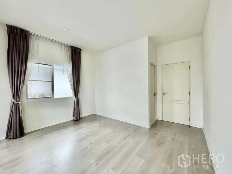 บ้าน ให้เช่าในPrawet, Bangkok - ห้องเปล่ามีหน้าต่าง ผ้าม่านสีน้ำตาล ประตูสีขาว และพื้นลามิเนตไม้.