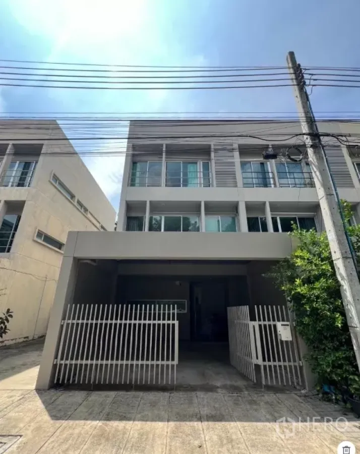 Townhouse for rent in Suan Luang, Bangkok - Modern three-storey townhouse facade with gated carport at Noble Cube Suan Luang.