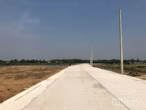 Land for sale in Bang Pakong, Chachoengsao - Wide estate road with utility poles and cleared plots in Bang Pakong industrial area near the Motorway.