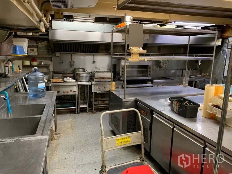 零售空间 出租在Bang Rak, Bangkok - 带排烟罩、水槽和不锈钢工作台的专业厨房，适合餐饮。