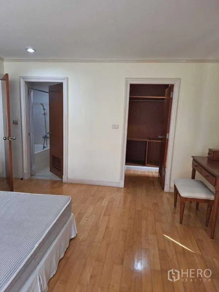 Apartment for rent in Watthana, Bangkok - Bedroom view toward a bathroom with bathtub and a built-in closet for storage.