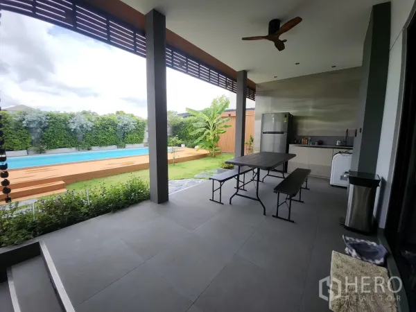 Detached House for rent in Bang Phli, Samut Prakan - Covered terrace with outdoor pantry and dining set overlooking the pool and garden.