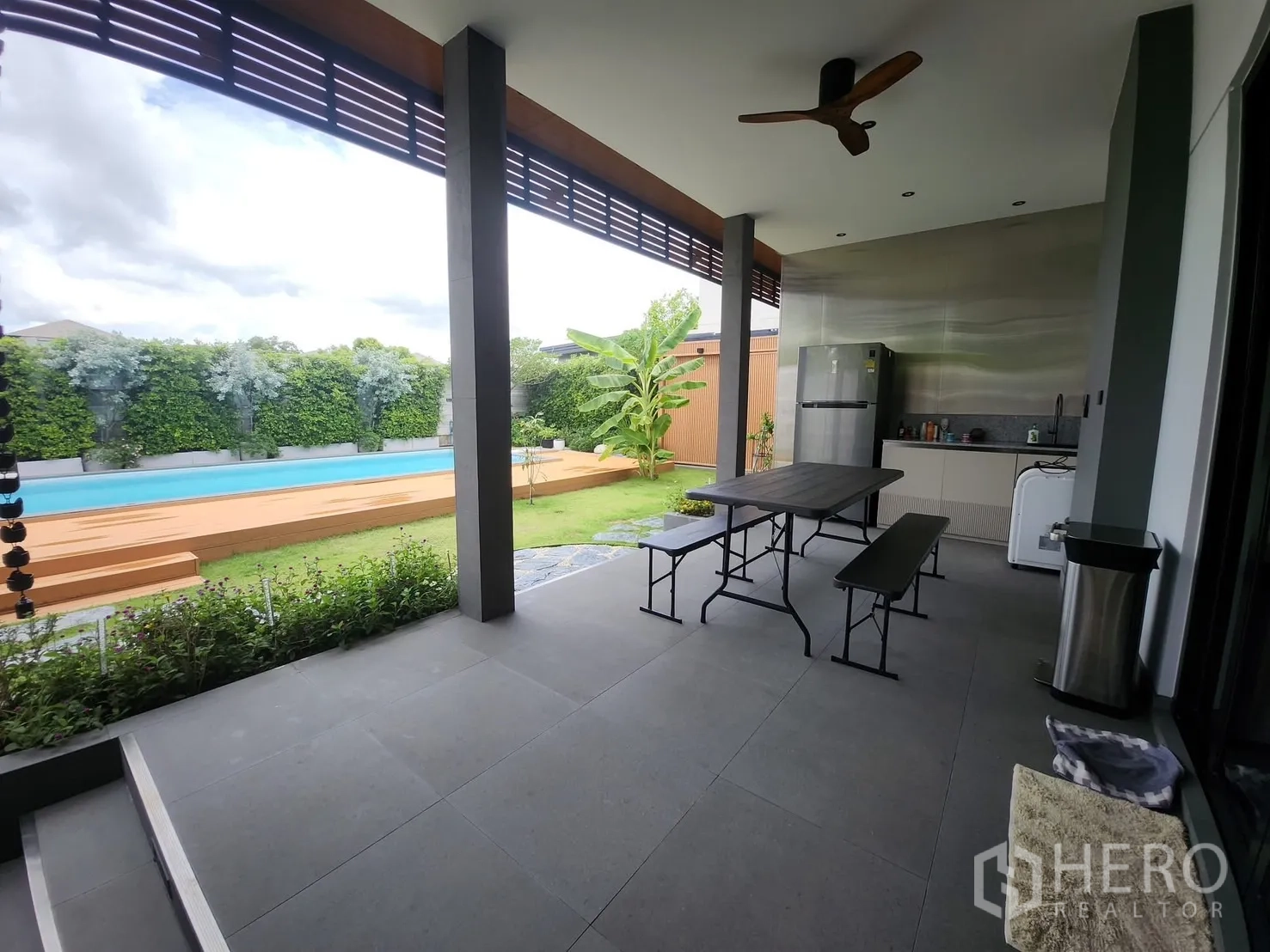 Detached House for rent in Bang Phli, Samut Prakan - Covered terrace with outdoor pantry and dining set overlooking the pool and garden.