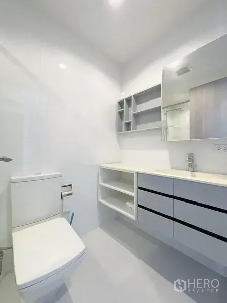 คอนโด ขายในWatthana, Bangkok - ห้องน้ำโทนขาวสว่าง มีอ่างล้างหน้าแบบลอย ชั้นเก็บของ และโถสุขภัณฑ์ ในคอนโดทองหล่อ