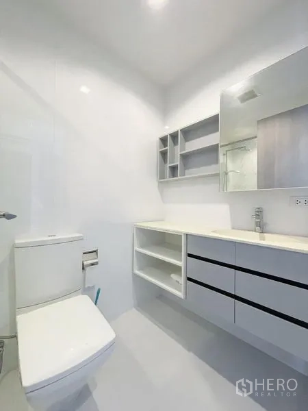 คอนโด ขายในWatthana, Bangkok - ห้องน้ำโทนขาวสว่าง มีอ่างล้างหน้าแบบลอย ชั้นเก็บของ และโถสุขภัณฑ์ ในคอนโดทองหล่อ