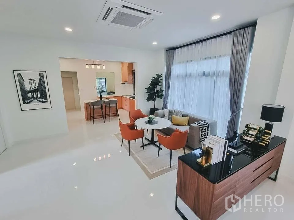 Detached House for rent or sale in Bang Phli, Samut Prakan - Open-plan family area with round dining table, orange chairs, and breakfast bar.