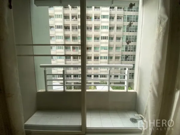 คอนโด ให้เช่าในBang Kapi, Bangkok - ระเบียงขนาดกะทัดรัด ประตูกระจกบานเลื่อน มุมมองอาคารใกล้เคียง