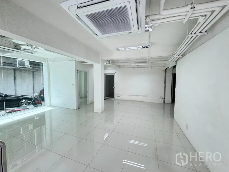 零售空间 出租在Bang Rak, Bangkok - 明亮的开放式零售室内，白色瓷砖地面、整面玻璃门面与嵌入式天花空调。