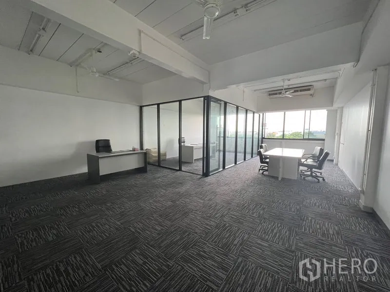 Office Space for rent in Mueang Samut Prakan, Samut Prakan - Carpeted office with glass-partitioned meeting rooms and desks.