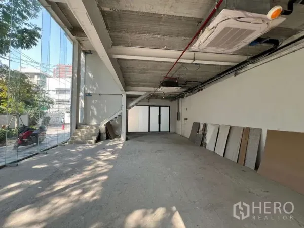 พื้นที่ขายปลีก ให้เช่าในWatthana, Bangkok - มุมมองยาวภายใน พร้อมบันได เครื่องปรับอากาศ และผนังกระจกหน้าอาคาร