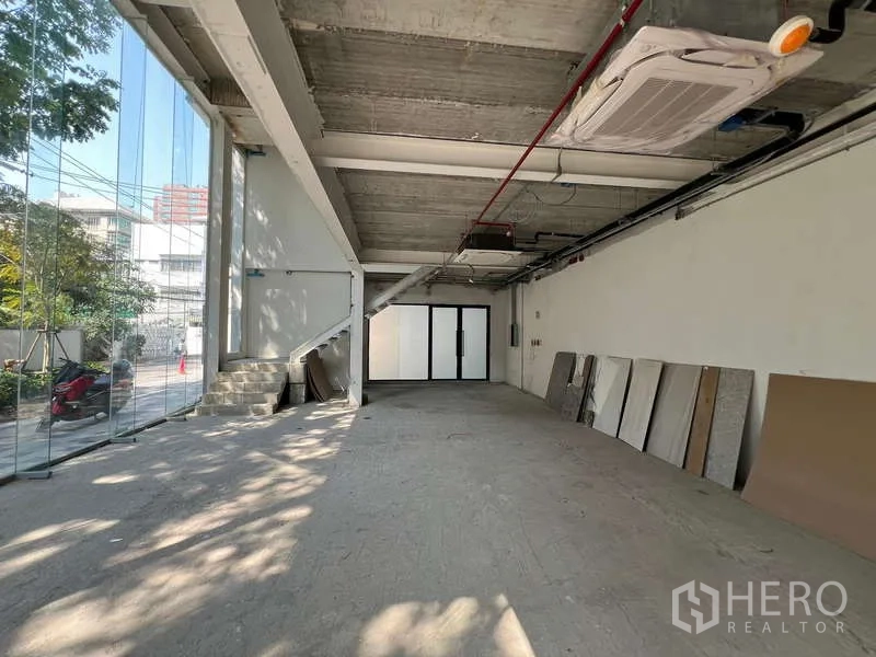 พื้นที่ขายปลีก ให้เช่าในWatthana, Bangkok - มุมมองยาวภายใน พร้อมบันได เครื่องปรับอากาศ และผนังกระจกหน้าอาคาร