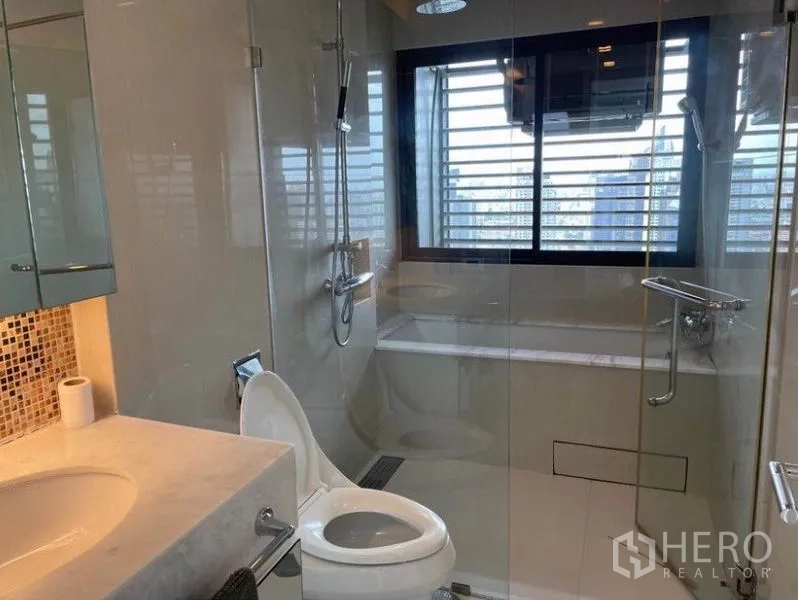 公寓 出售在Ratchathewi, Bangkok - 现代浴室，玻璃淋浴间与浴缸，窗外是城市景色。
