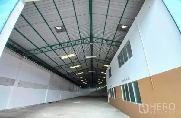 คลังสินค้า ให้เช่าในMueang Samut Prakan, Samut Prakan - ภายในโกดังโปร่ง โครงหลังคาเหล็กสูง มีสกายไลต์ และออฟฟิศด้านข้างพร้อมหน้าต่าง