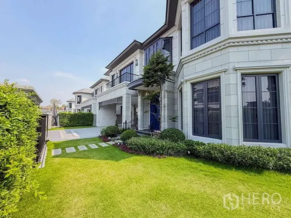 Detached House for rent or sale in Bang Kapi, Bangkok - Elegant two-storey detached house facade with manicured front lawn and stepping-stone path.