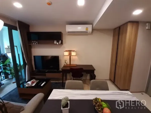 คอนโด ให้เช่าหรือขายในWatthana, Bangkok - ห้องนั่งเล่นมีชั้นลอย โต๊ะทำงาน ชุดทีวี และเครื่องปรับอากาศติดผนังข้างระเบียง