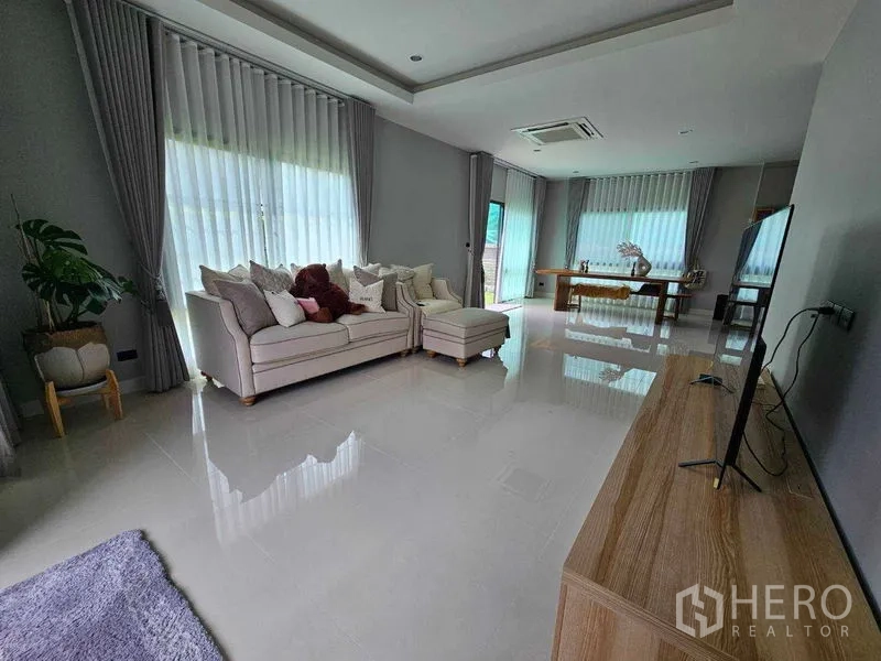 Detached House for rent in Mueang Pathum Thani, Pathum Thani - Open-plan living and dining space with TV cabinet and glossy floors