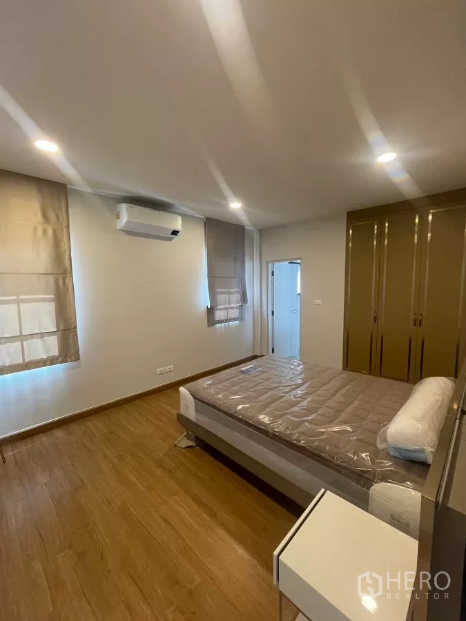 Detached House for rent in Bang Phli, Samut Prakan - Guest bedroom with wood flooring, bed and built-in wardrobes.