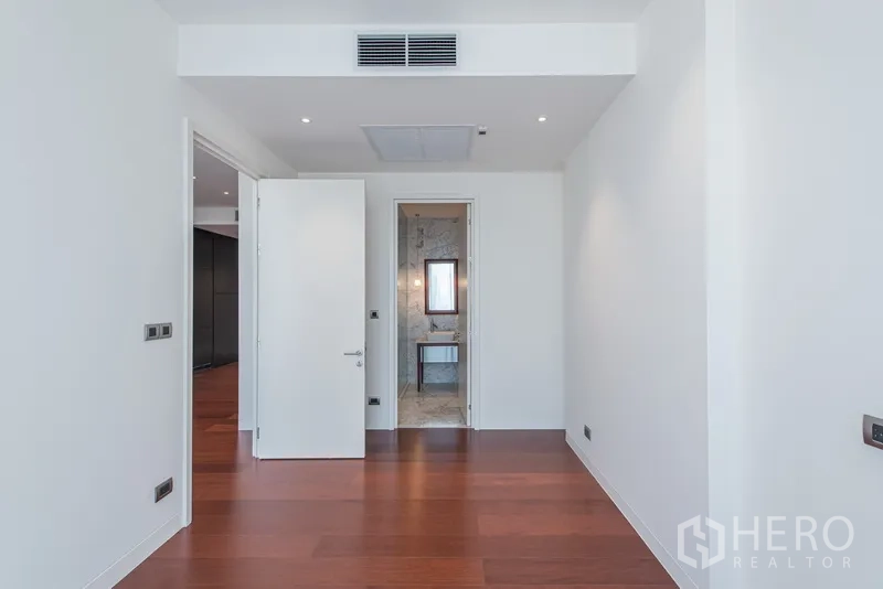 公寓 出售在Watthana, Bangkok - 卧室配木地板、白墙、吊顶出风口，并设套内卫浴入口。