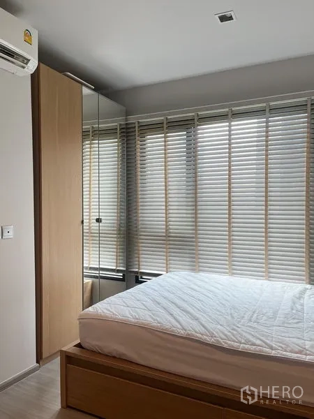 Condominium for sale in Ratchathewi, Bangkok - Minimalist bathroom view with white sink, beige tiles, and door.