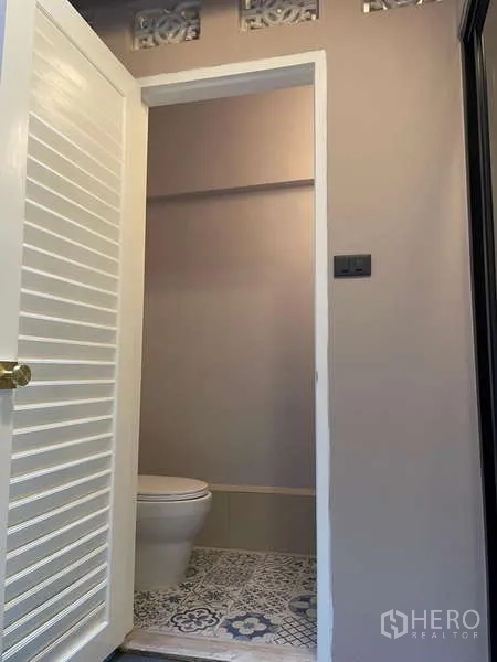 สำนักงานที่บ้าน ให้เช่าในWatthana, Bangkok - ห้องน้ำพร้อมโถสุขภัณฑ์ พื้นกระเบื้องลายและประตูบานเกล็ดสีขาว.