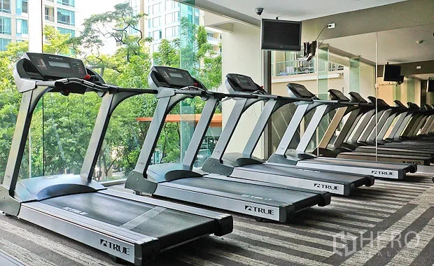 公寓 出租在Pathum Wan, Bangkok - 公寓健身房，整排跑步机面向镜面与花园景观。