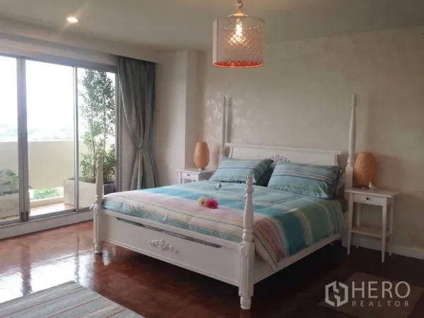 คอนโด ให้เช่าในKhlong Toei, Bangkok - ห้องนอนหลักเตียงคิงส์ไซส์ ประตูกระจกบานเลื่อนออกสู่ระเบียง พื้นไม้เงางาม