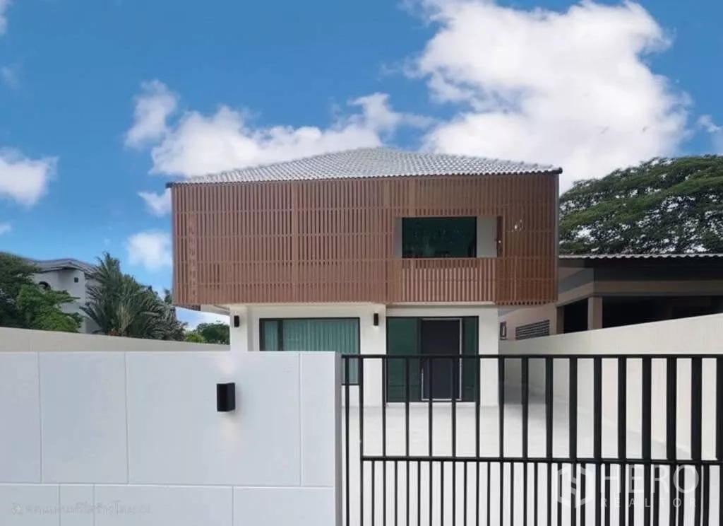 独立式住宅 出售在Prawet, Bangkok - 现代两层独栋别墅外立面，木格栅装饰与金属大门车道，位于曼谷Prawet区。