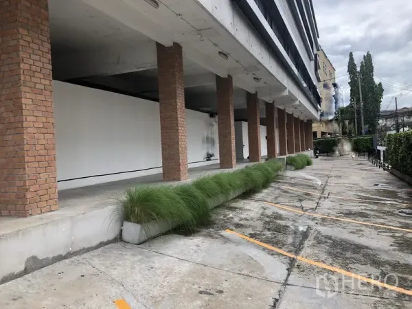Office Space for rent in Khlong Toei, Bangkok - Building exterior with brick pillars and on-site parking bays in Phra Khanong.
