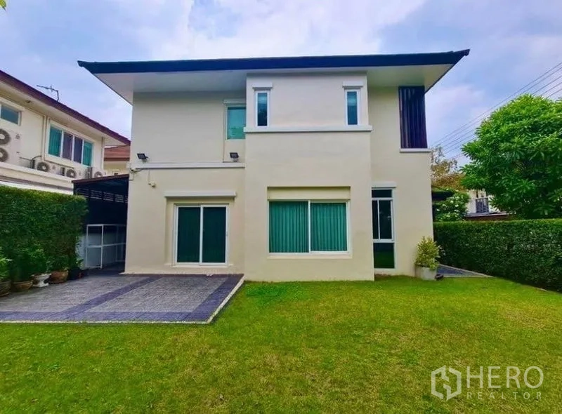 บ้าน ให้เช่าหรือขายในLat Krabang, Bangkok - มุมมองด้านหลังบ้านสองชั้นสไตล์โมเดิร์น มีหน้าต่างบานใหญ่ ลานจอดรถและสนามหญ้า