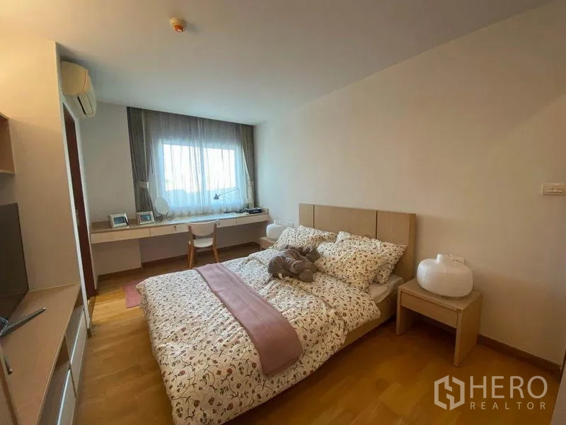 公寓 出租或出售在Phra Khanong, Bangkok - 宽敞主卧配大床、床头柜及窗下长书桌。