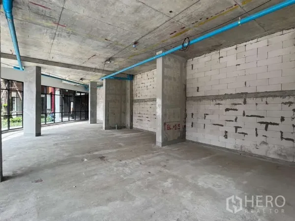 零售空间 出租在Phra Khanong, Bangkok - 室内毛坯层，高天花、混凝土柱与外露管线