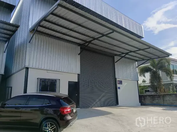 货栈 出租在Bang Phli, Samut Prakan - 邦普里新建仓库外观，宽大卷帘门、雨棚与停车区。