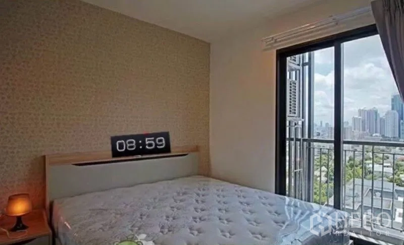 Condominium for rent in Khlong Toei, Bangkok - Bedroom with large window and balcony access showcasing skyline views.