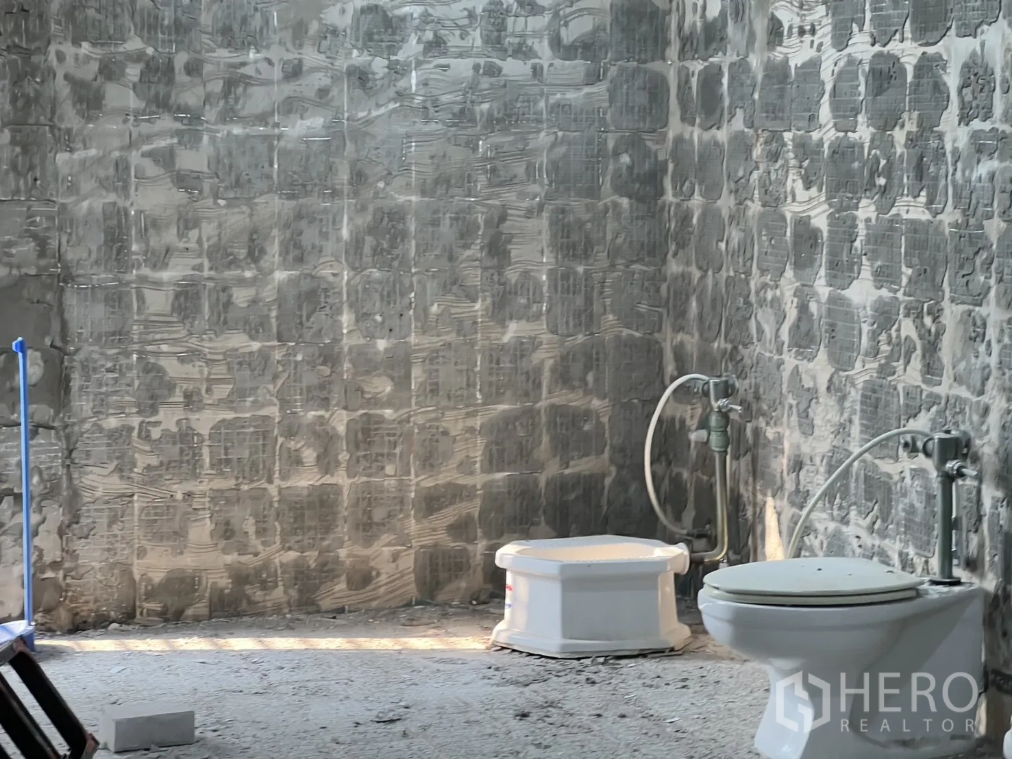 办公空间 出租在Watthana, Bangkok - 卫生间在翻新中，地面洁具与未完成的混凝土墙面。