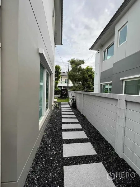 บ้าน ให้เช่าหรือขายในLat Krabang, Bangkok - สนามหญ้าหน้าบ้านและด้านหน้าอาคาร พร้อมกันสาดและโรงจอดรถ