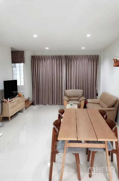 Home Office for rent or sale - Dining area facing a TV lounge with large drapes and comfortable seating.