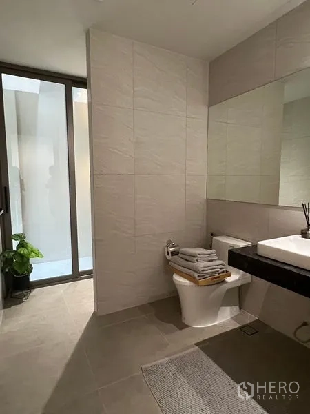 联排别墅 出售在Lat Phrao, Bangkok - 极简浴室，大片镜面与中性色瓷砖及玻璃门