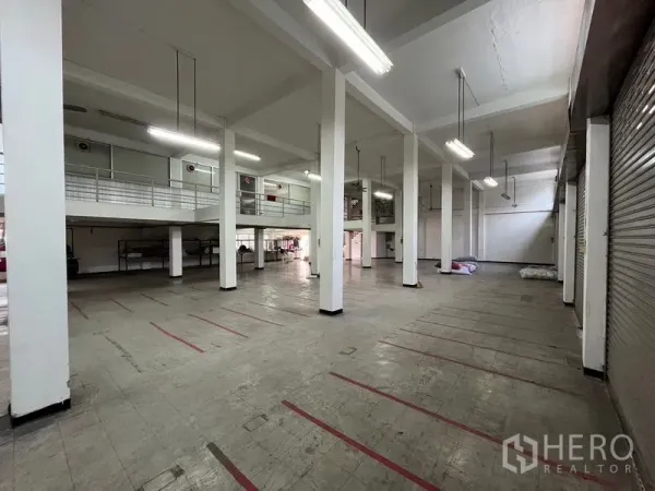 อาคารพาณิชย์ ให้เช่าในKhlong Toei, Bangkok - โถงชั้นล่างเพดานสูง มีชั้นลอย ไฟส่องสว่างยาว และประตูม้วน เหมาะสำหรับโหลดสินค้า