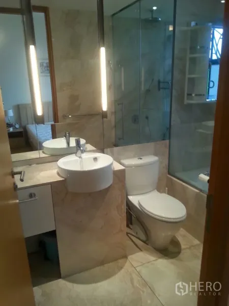 Condominium for rent or sale in Sathon, Bangkok - Modern bathroom with glass shower enclosure, backlit mirror and white vanity.
