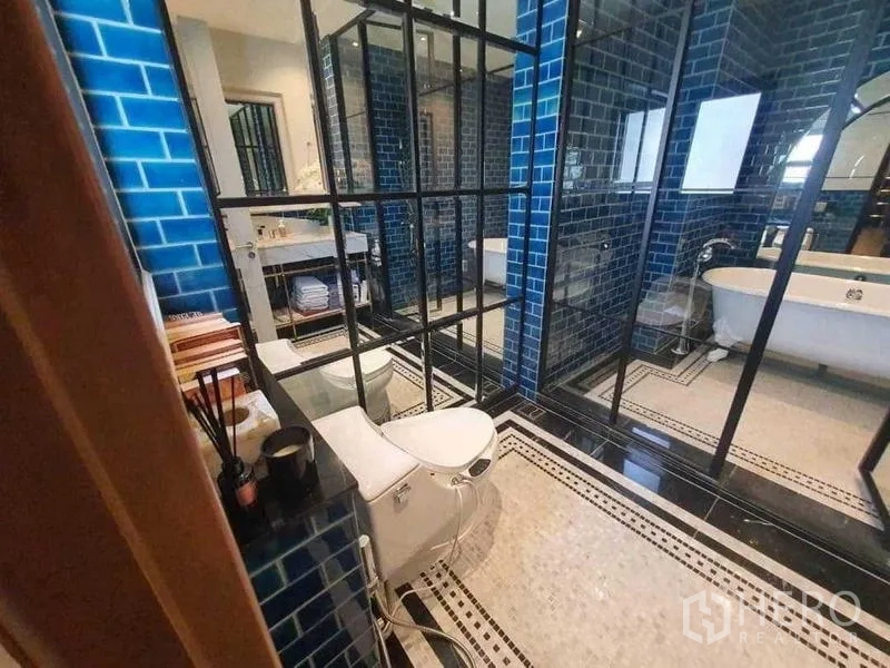 Detached House for rent or sale in Prawet, Bangkok - Designer bathroom with blue subway tiles, glass partitions and vanity.