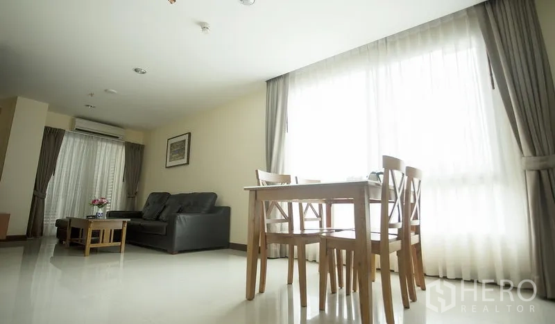 อพาร์ทเมนท์ ให้เช่าในKhlong Toei, Bangkok - ห้องนั่งเล่นเชื่อมพื้นที่ทานอาหาร มีหน้าต่างบานใหญ่และโซฟาหนัง