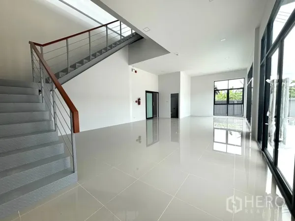 Factory for rent or sale in Bang Bo, Samut Prakan - Ground-floor office and showroom with large windows and a metal staircase in a new factory.