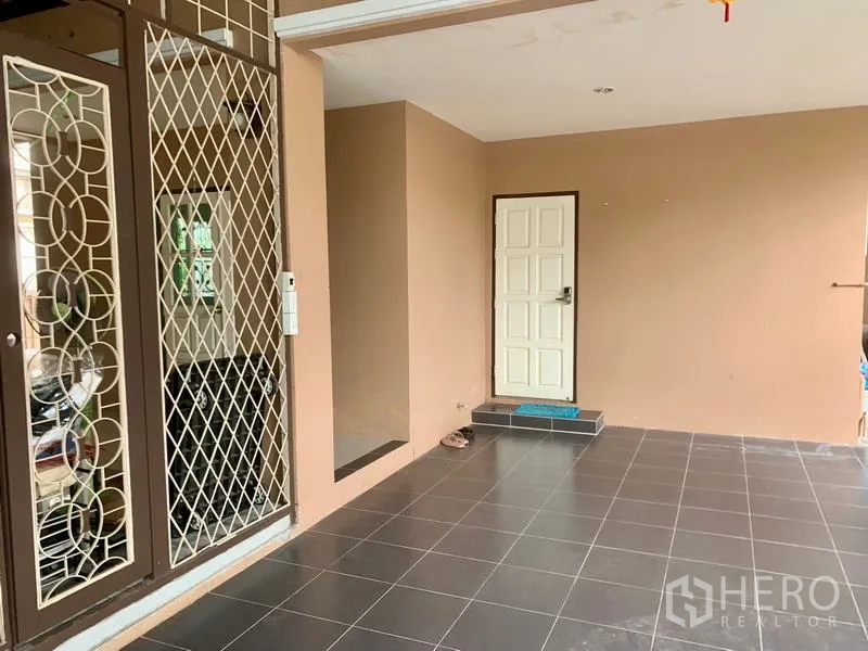 Detached House for rent in Khlong Sam Wa, Bangkok - Entrance nook off the carport featuring a white door and tiled flooring.