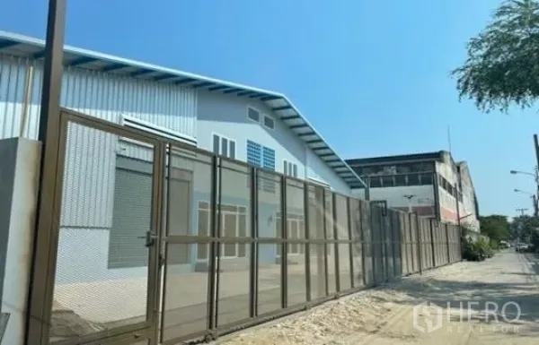 货栈 出租在Prawet, Bangkok - 街景视角的安全仓库，高金属围栏、卷闸门与装卸区