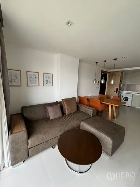 คอนโด ให้เช่าในWatthana, Bangkok - มุมมองอีกด้านของห้องนั่งเล่น แสดงโซฟาเข้ามุม ชุดทานอาหาร และครัว